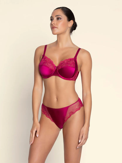 Woman wearing a red lingerie set on a beige background