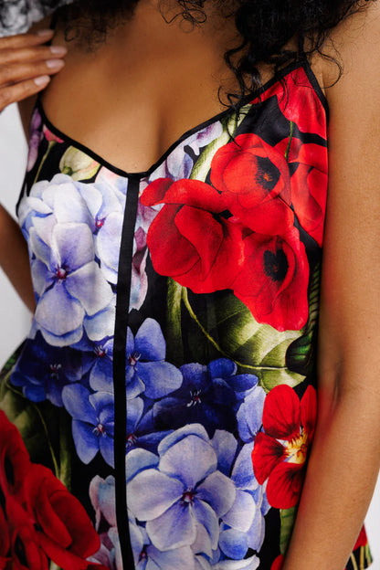 Close-up of a floral silk set of top and shorts  with red and blue flowers on a black background.